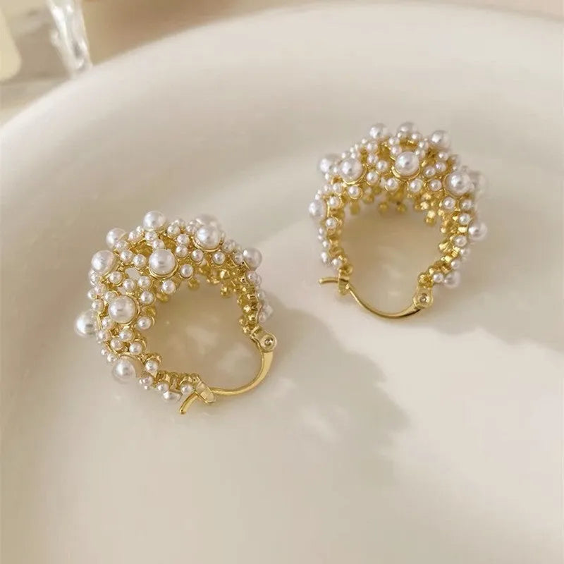 Gold-coloured copper flower basket earrings with white pearl inlay and small rice-shaped bead details.