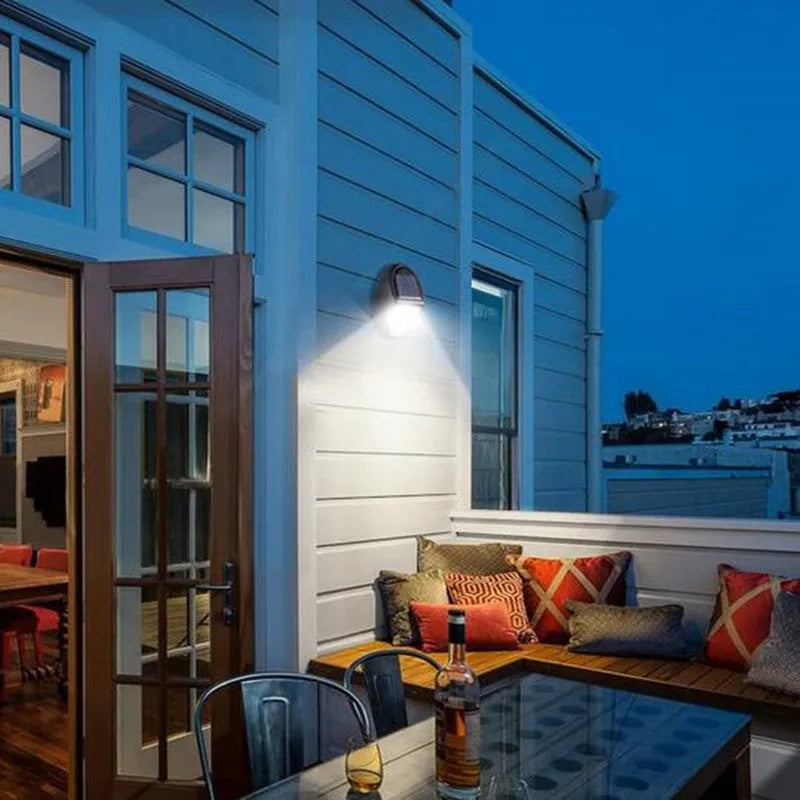 Black rectangular LED solar wall light for outdoor mounting with a solar panel on top.