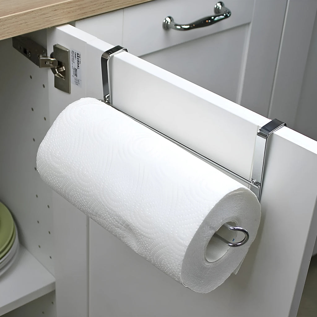 Silver stainless steel paper towel rack hanging on a wooden cabinet door.