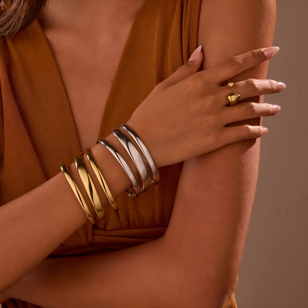 A simple open geometric stainless steel bracelet for women, shown in a gold tone finish.