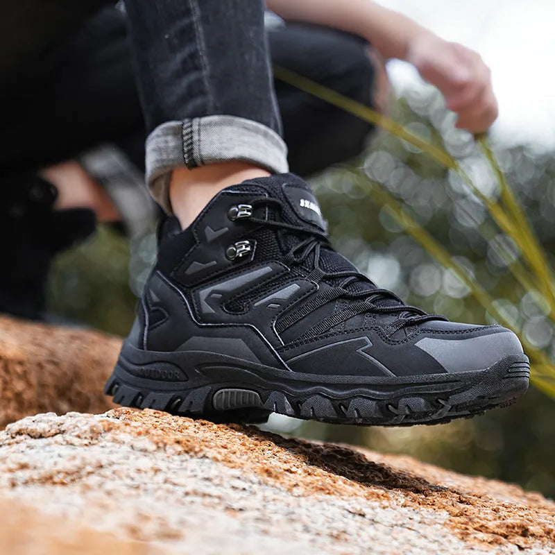 Flannel upper hiking sneakers with rubber soles in light brown colour on a rocky path.
