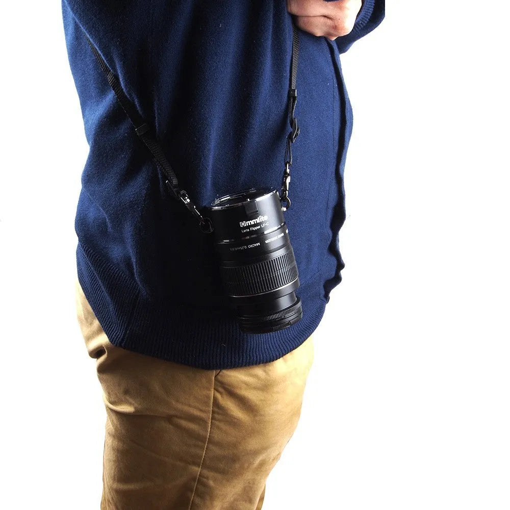 Aluminium camera lens flipper holder on a cotton shoulder strap for quick lens changes.