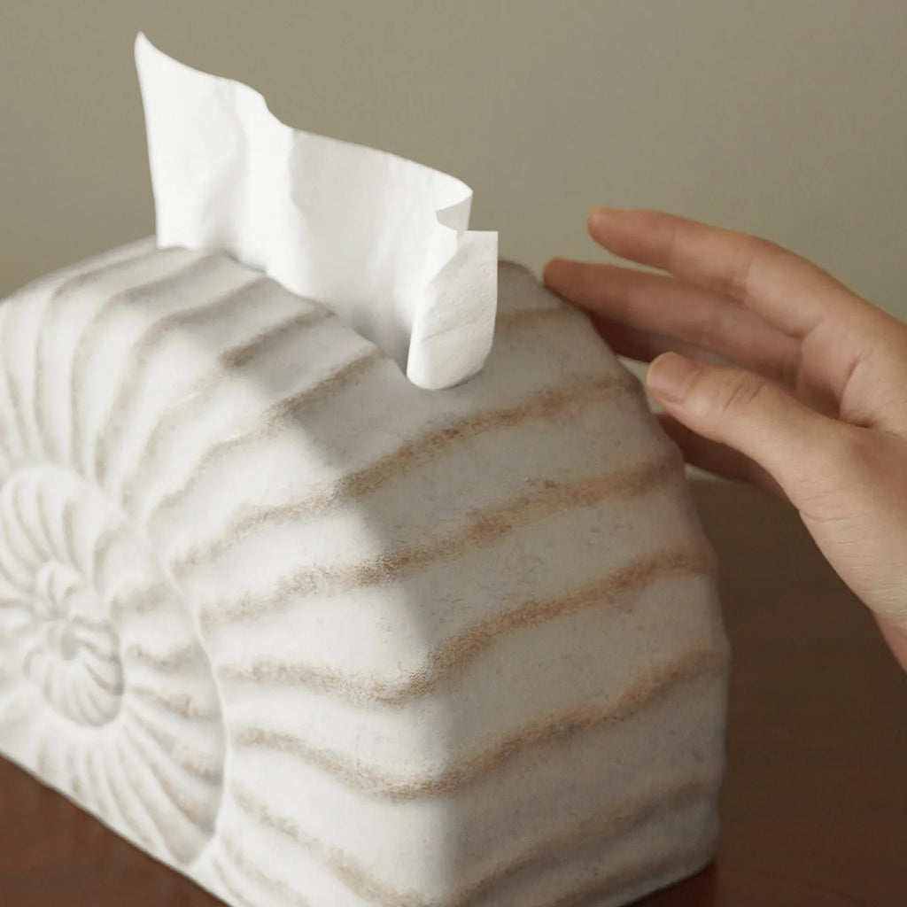 Modern conch ramble patterned resin decorative tissue box holder on a table.