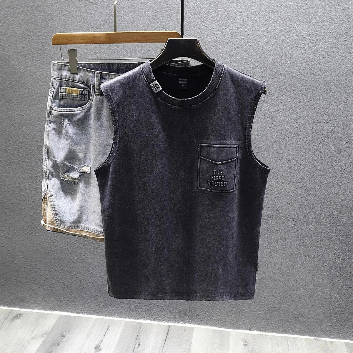 A white loose-fit cotton sleeveless t-shirt with a straight hem, laid flat.