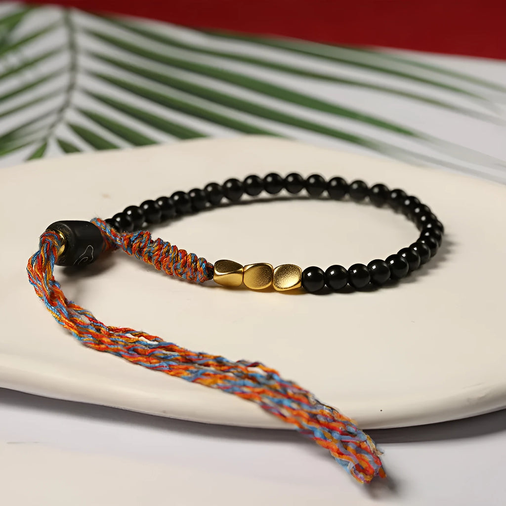 Hand-woven obsidian carrying strap bracelet showing 4mm width and adjustable length