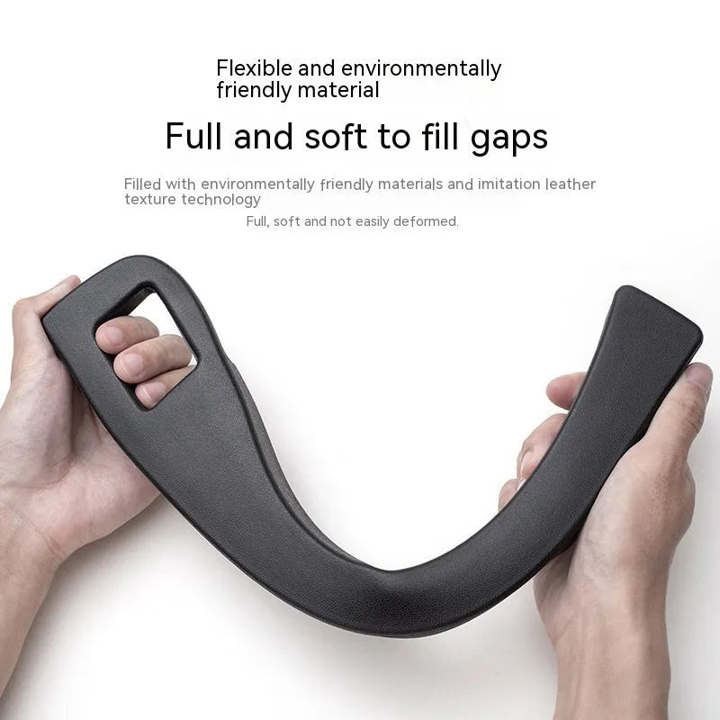 Black plastic car seat gap storage box with handle inserted between vehicle front seats.
