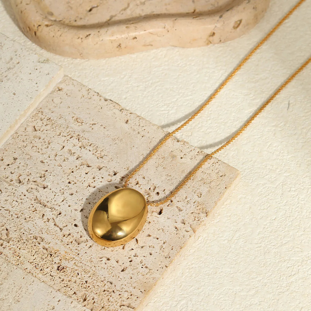 Gold geometric pendant on an adjustable stainless steel necklace chain.