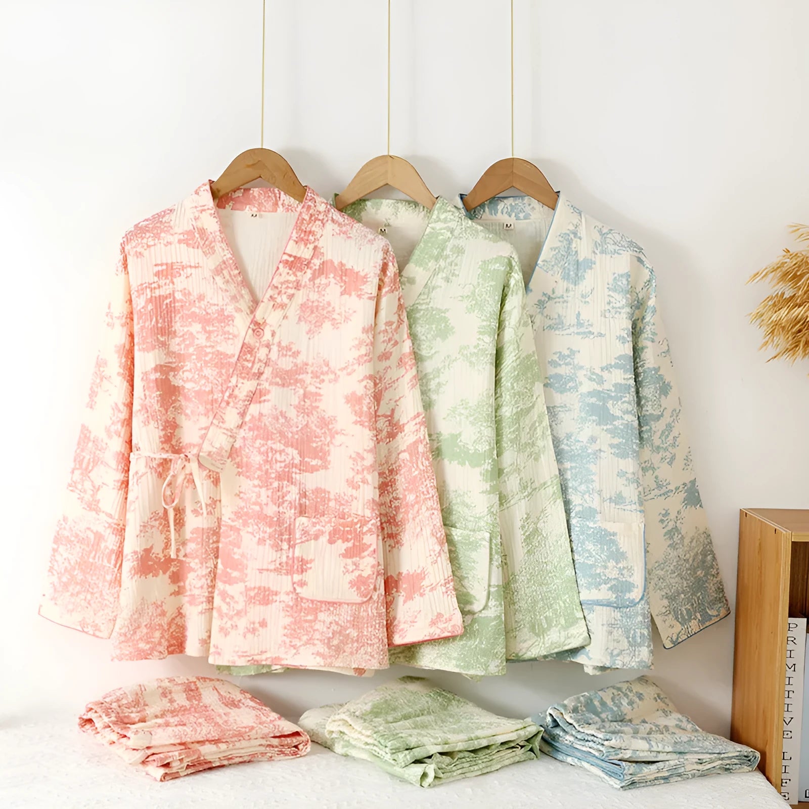Women's pink pure cotton gauze suit with long sleeves and lace-up trousers on a hanger.