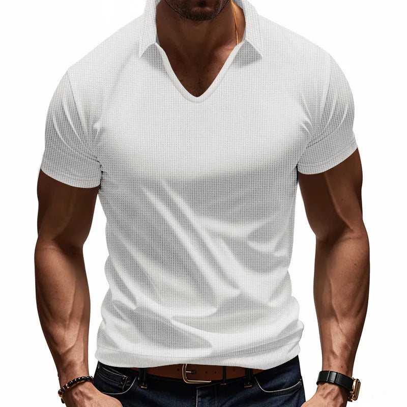 Man wearing a loose-fitting apricot V-neck short sleeve t-shirt against a plain background.