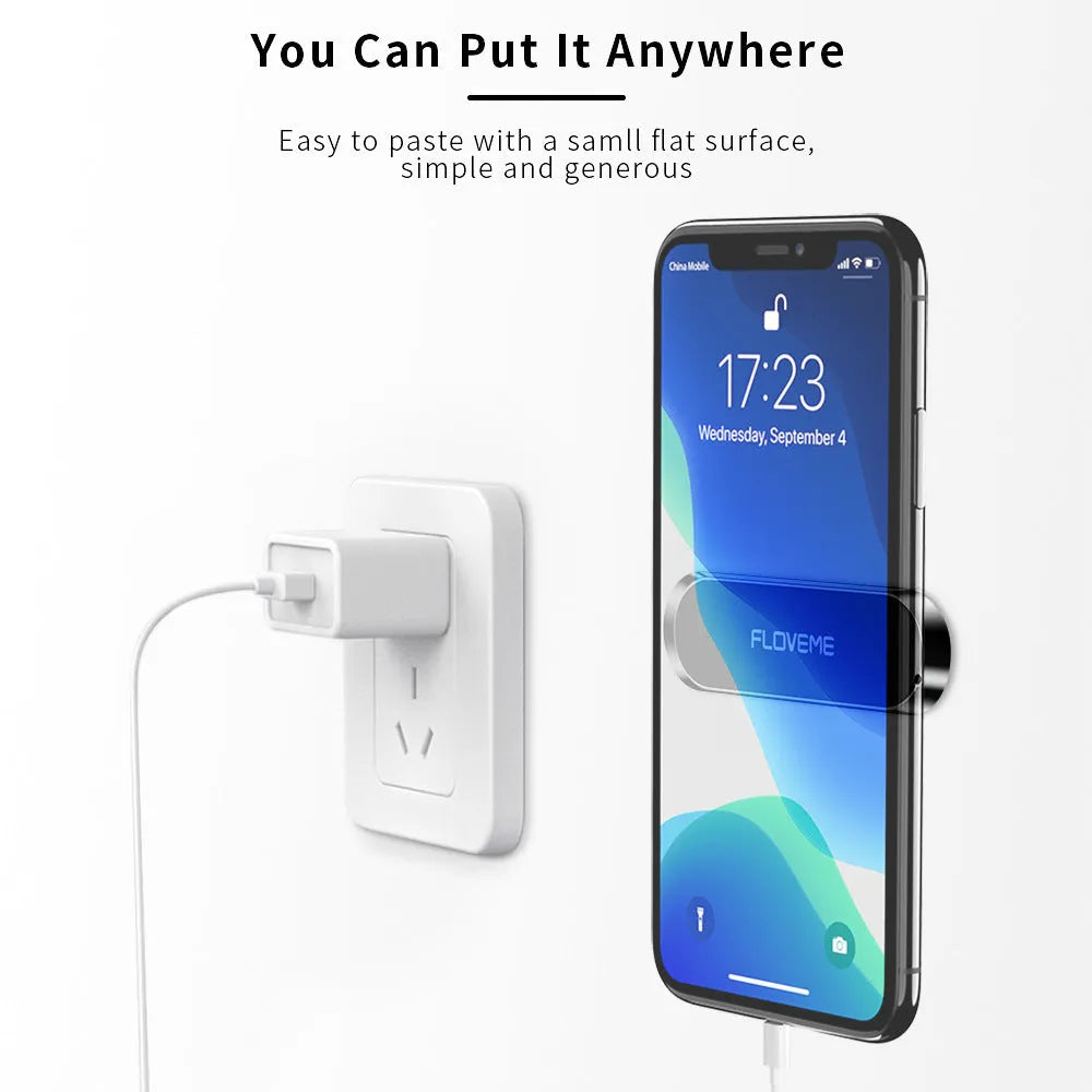Black magnetic mobile phone holder with silver iron sheet and white foam glue pad on a desk surface
