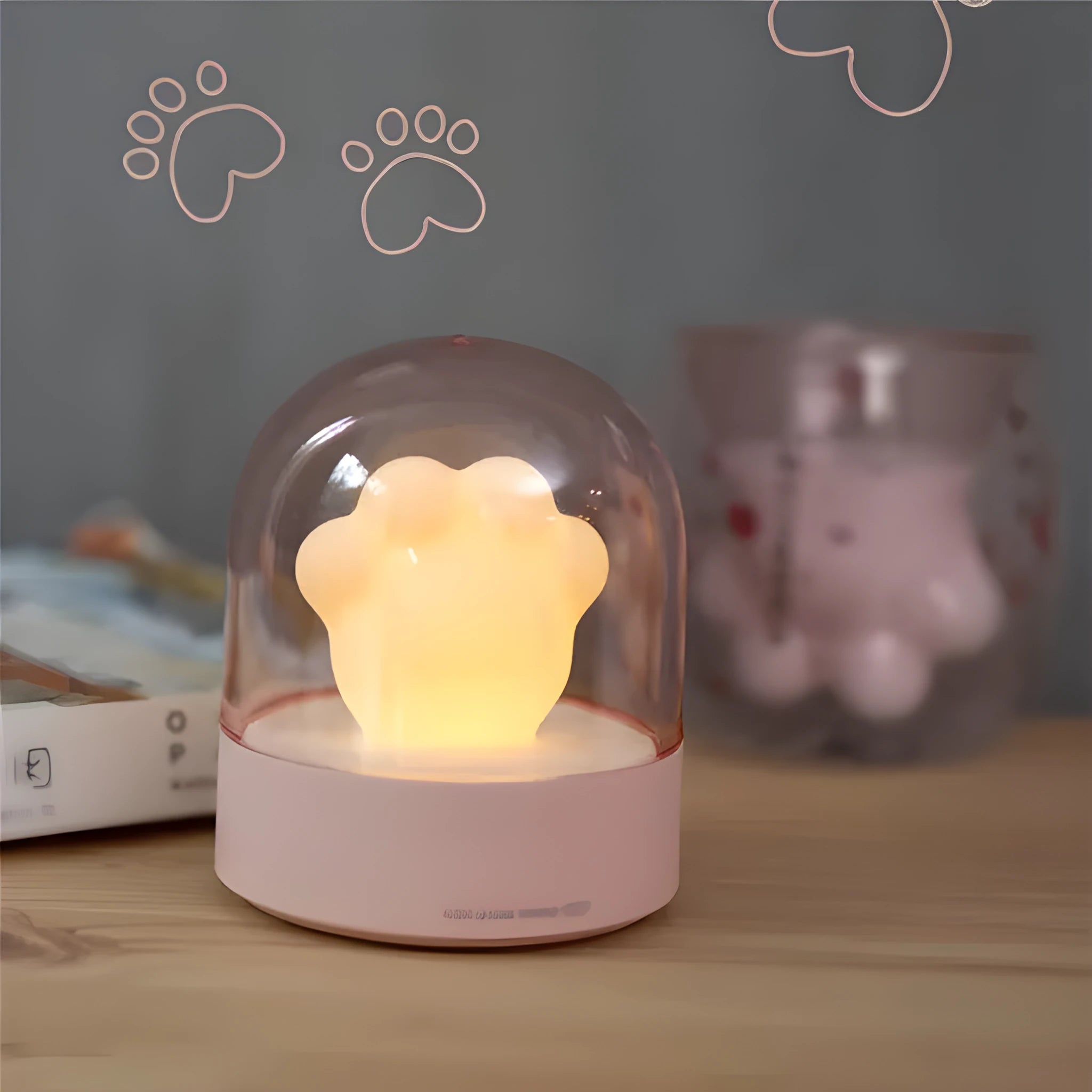 Grey or pink cat paw shaped USB rechargeable night light with music box on a desk.