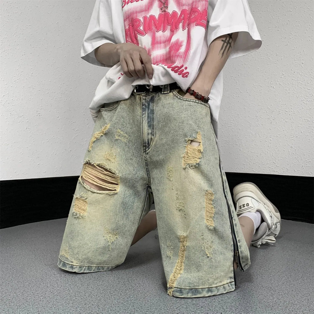 Men's loose five-point ripped denim shorts in blue with mud-yellow finish, button fly, and straight-leg cut