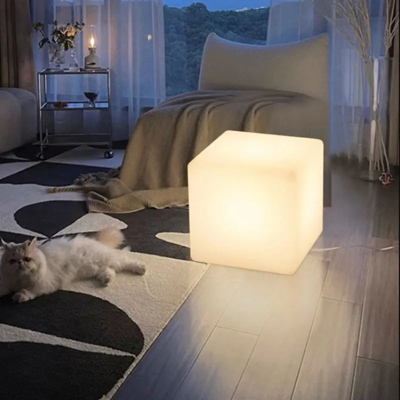 Modern square white LED cube light stool outdoors on a patio.