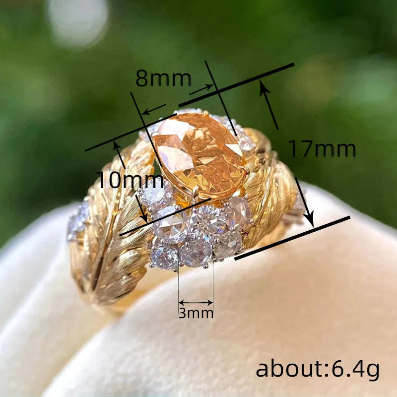 Women's gold-coloured copper ring with embossed feather pattern and yellow zircon stone in geometric setting