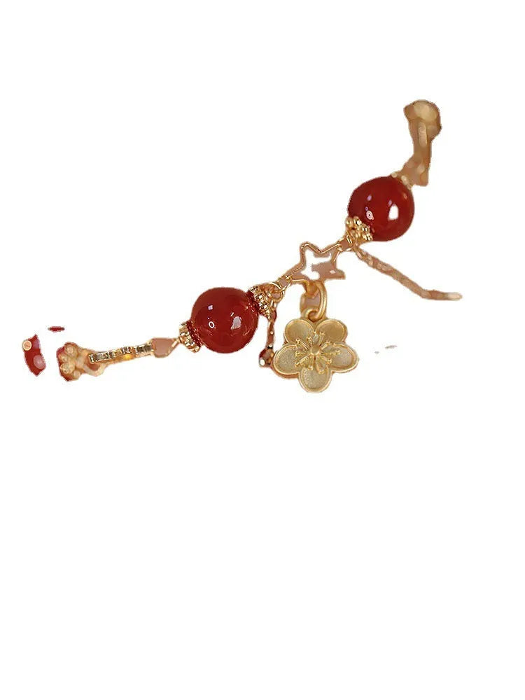 Red agate double layer bracelet with peach blossom charm on an adjustable elastic cord.