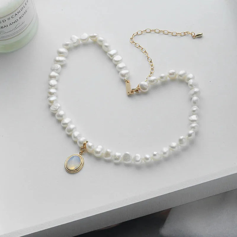 Close-up of a round 925 sterling silver necklace with an irregular geometric pearl pendant on a white background.