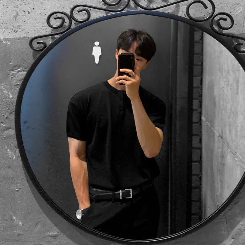 Man wearing a thin black slim-fit knitted short-sleeved shirt.