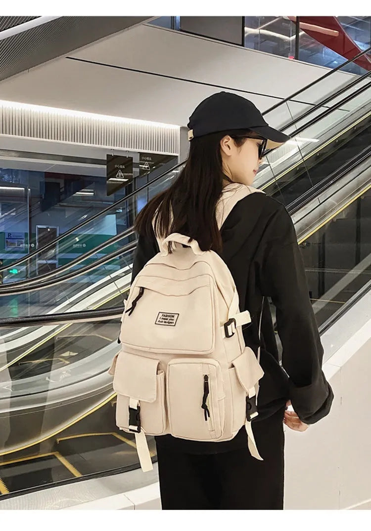 Black and white student nylon backpack with laptop compartment and outer pockets.
