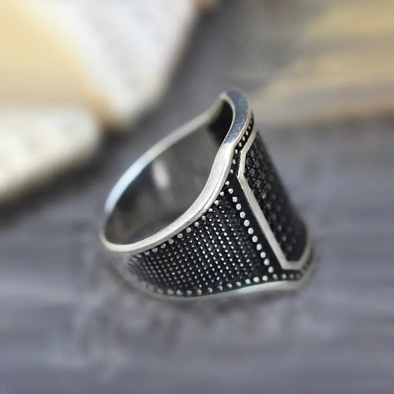 Black alloy ring with copper inlay and zircon stone, shown in unisex sizes 7 through 13.