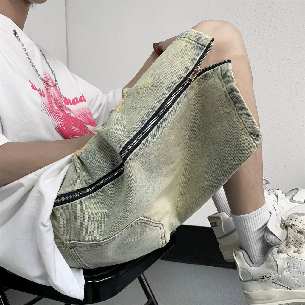 Men's loose five-point ripped denim shorts in blue with mud-yellow finish, button fly, and straight-leg cut