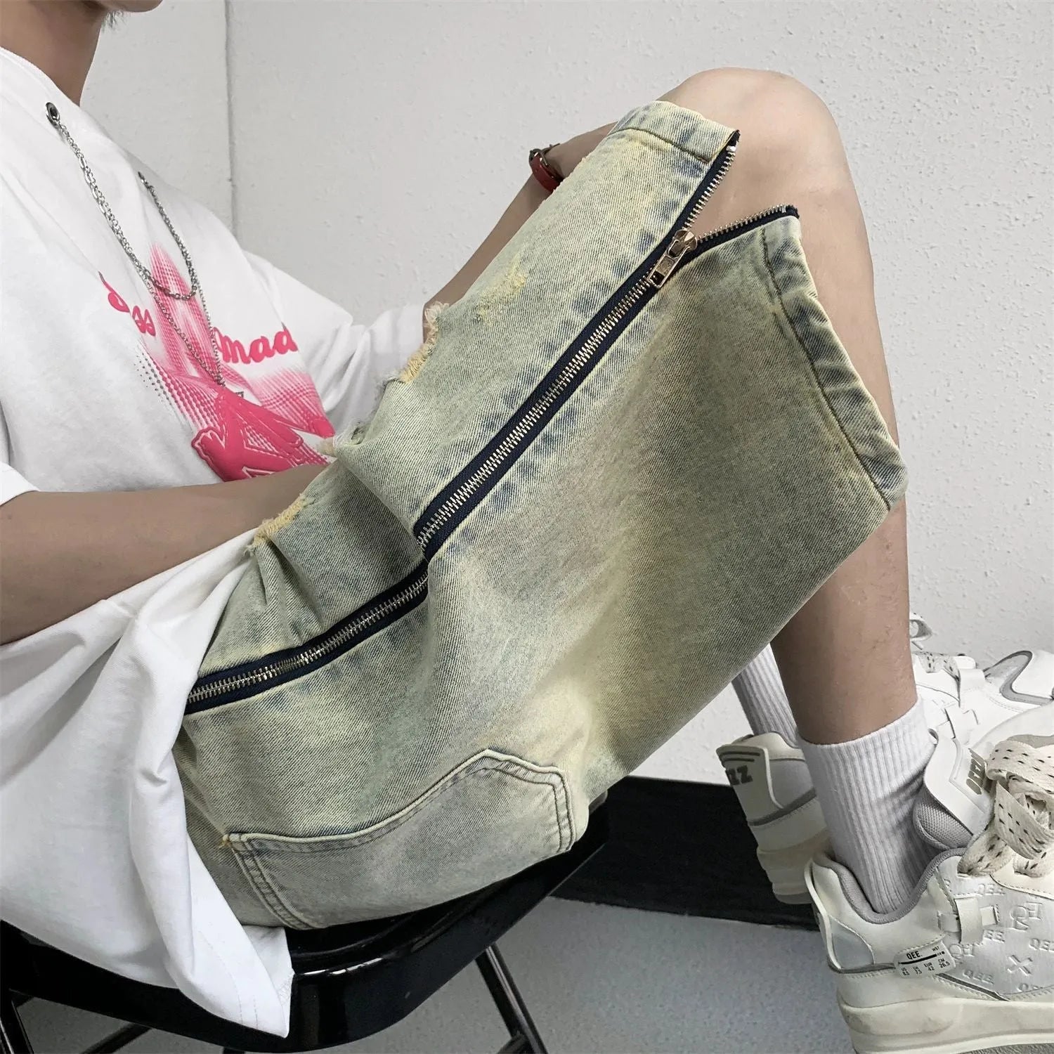 Men's loose five-point ripped denim shorts in blue with mud-yellow finish, button fly, and straight-leg cut