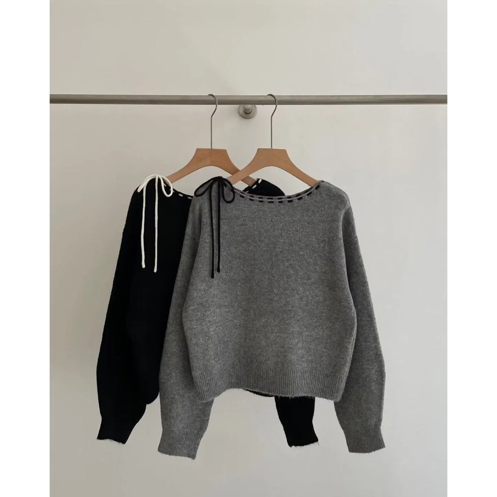 Women's loose-fitting grey knitwear pullover top with long sleeves on a hanger