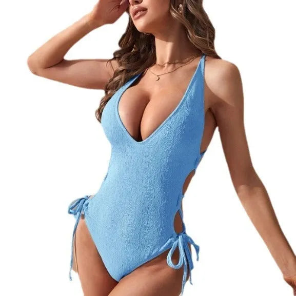 Women's black hollow backless one-piece polyester bikini swimsuit laid flat.