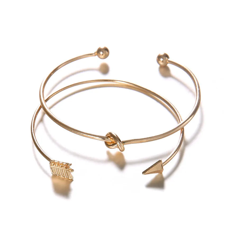 Gold vintage cuff bracelet for women with an arrow and knotted design detail.