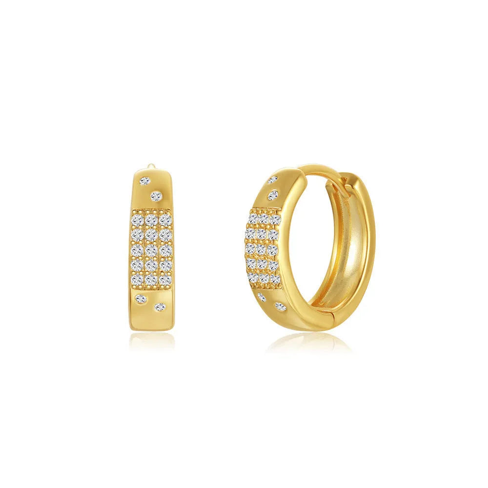 A pair of golden brass diamond-shaped earclip earrings with a round geometric design.