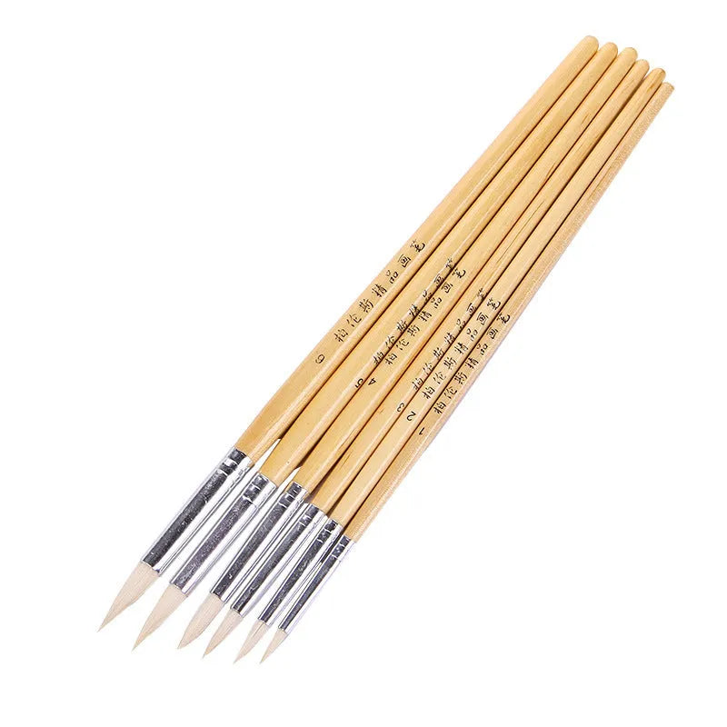 Six wooden handled artist brushes with pointed wool tips arranged as a complete set