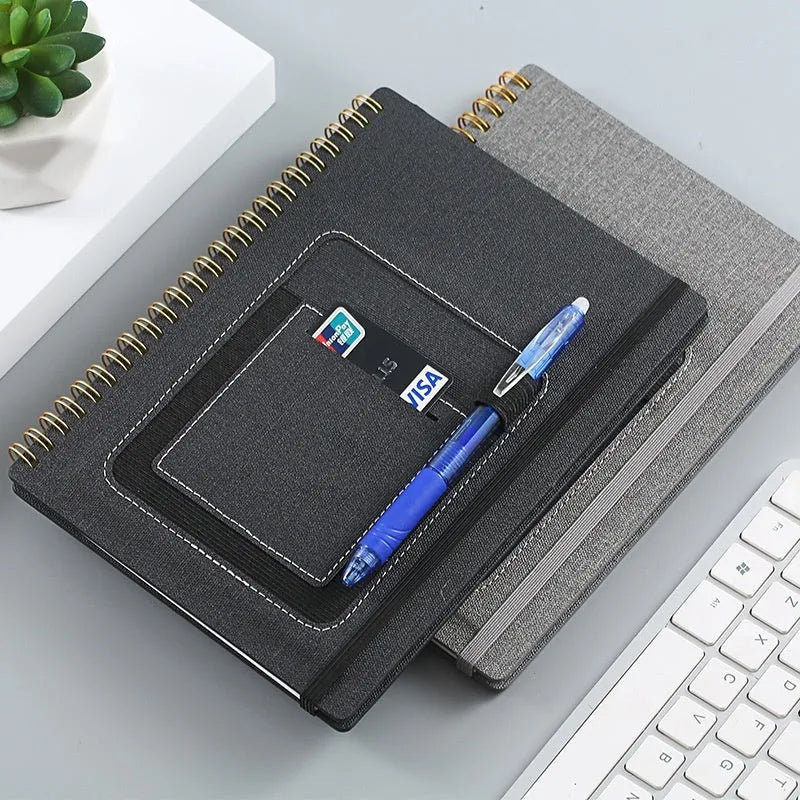 Erasable spiral notebook with stone paper, pen, and cloth on a wooden table