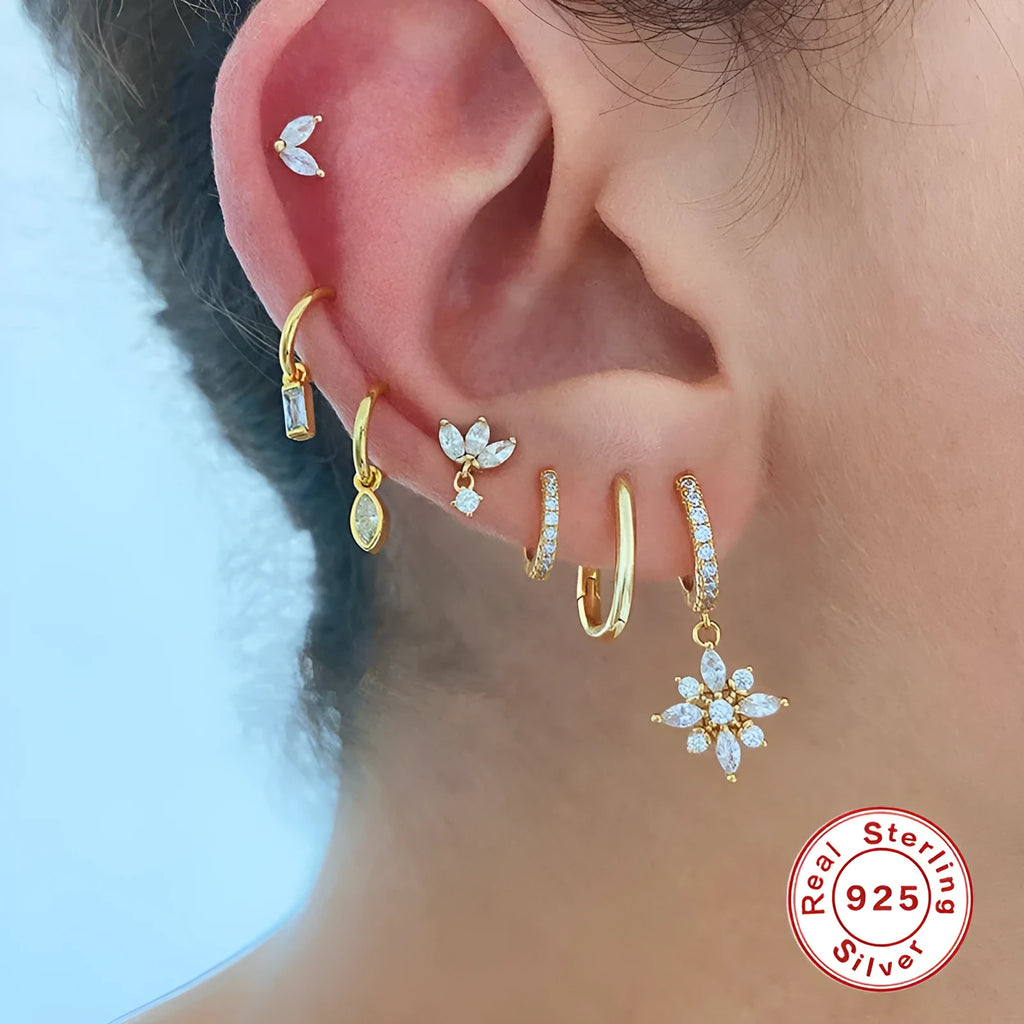 Pair of Sterling Silver snowflake pendant earrings on a yellow or white gold colour background.