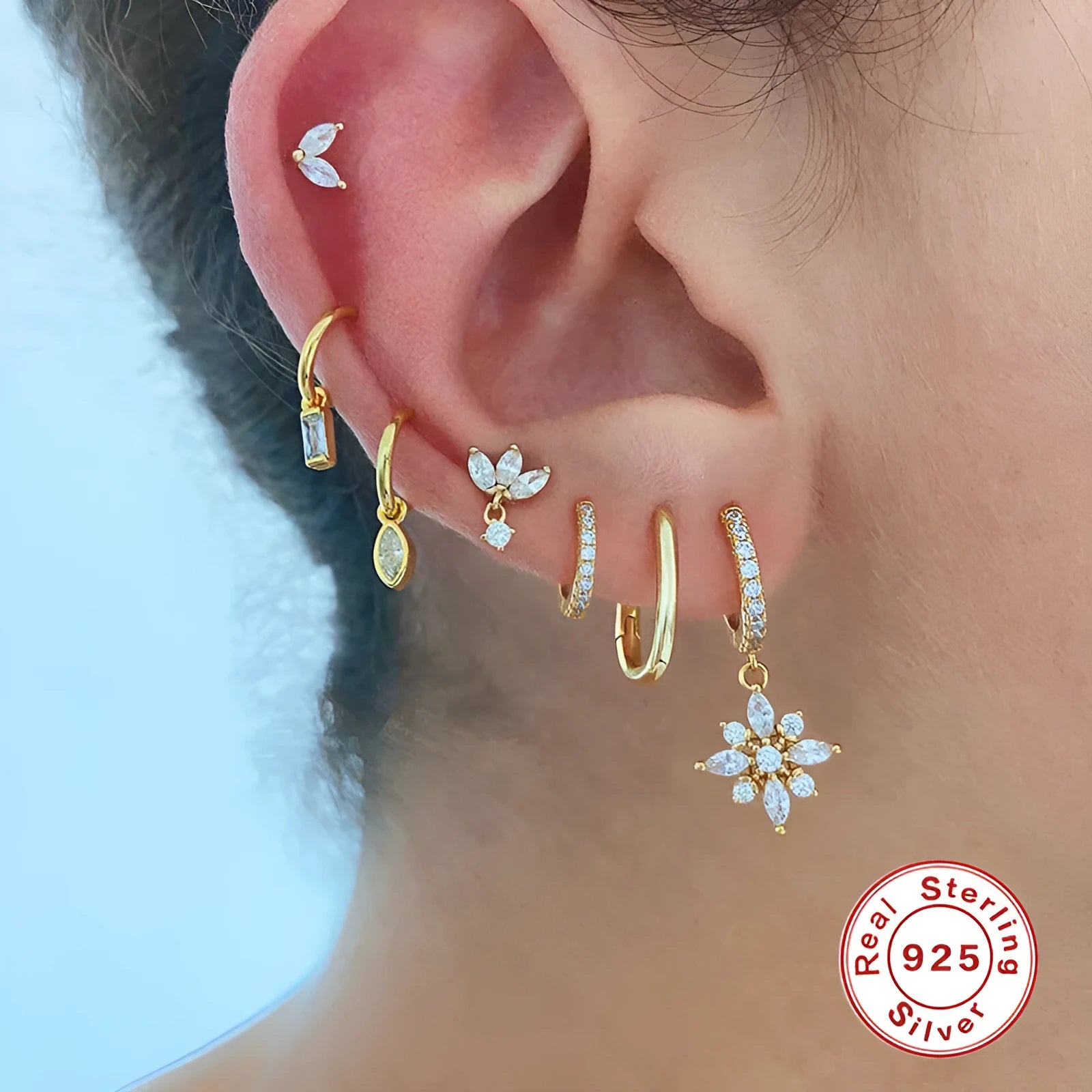 Pair of Sterling Silver snowflake pendant earrings on a yellow or white gold colour background.