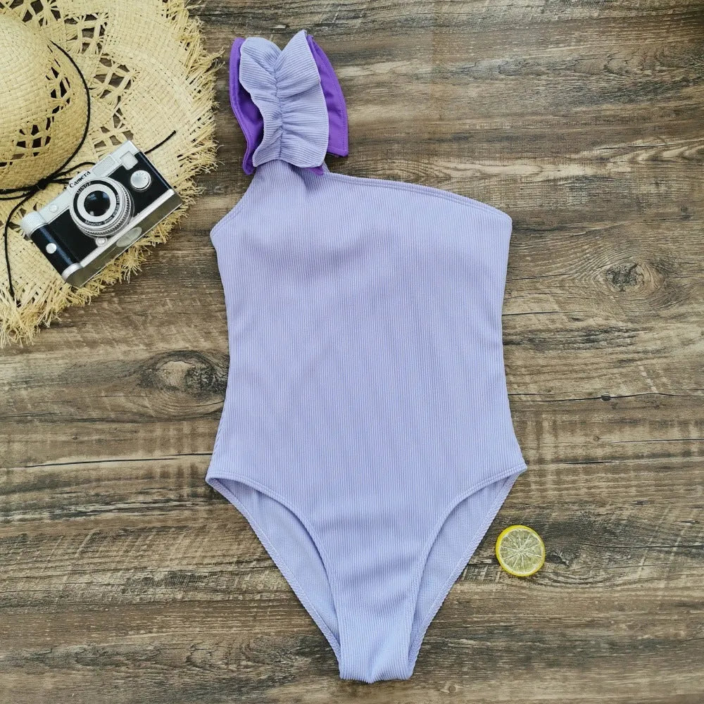 Women's single-shoulder suspender tube top one-piece swimsuit in a solid colour on a mannequin.