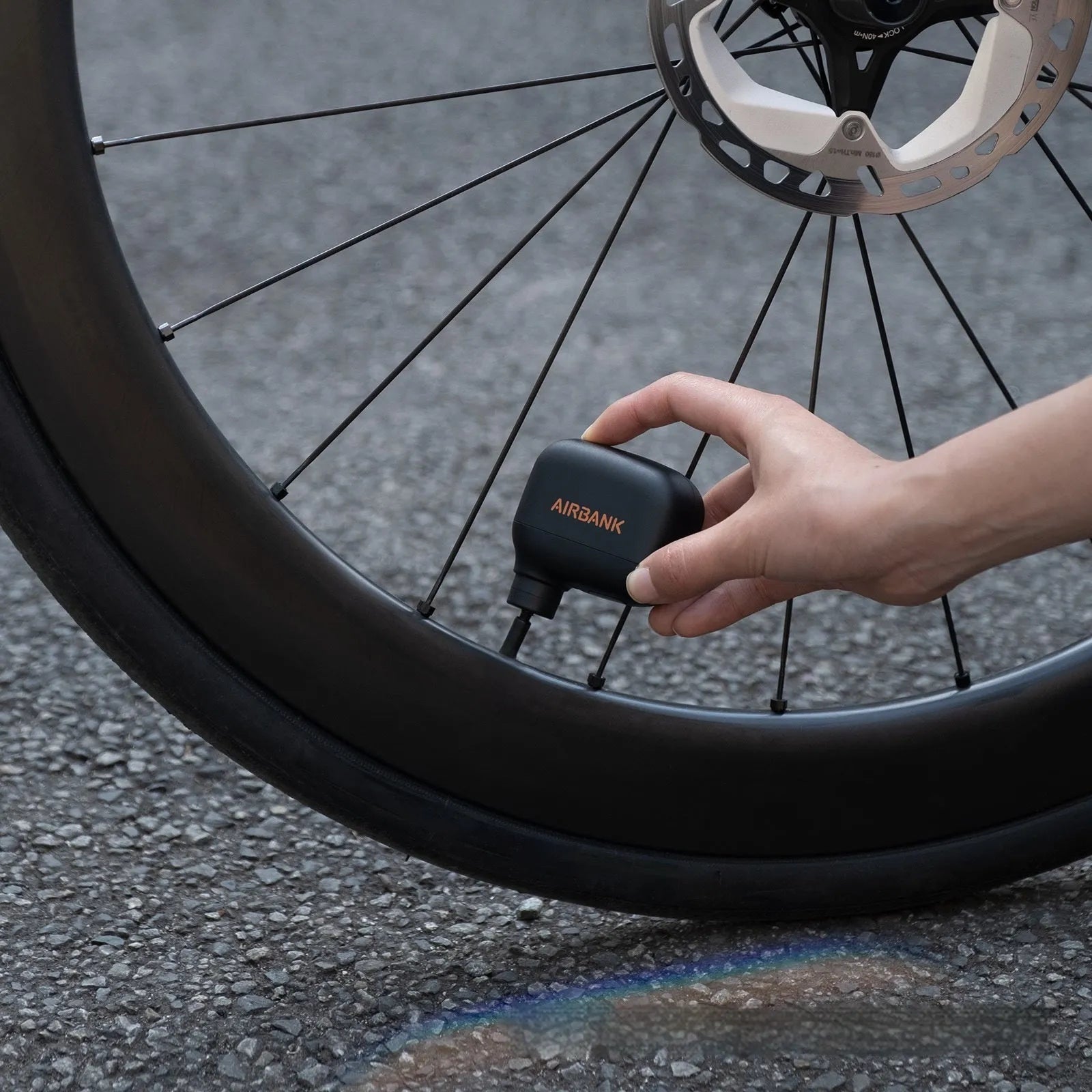 Black AS100 mini electric bike tyre pump with USB charging cable and waterproof storage bag