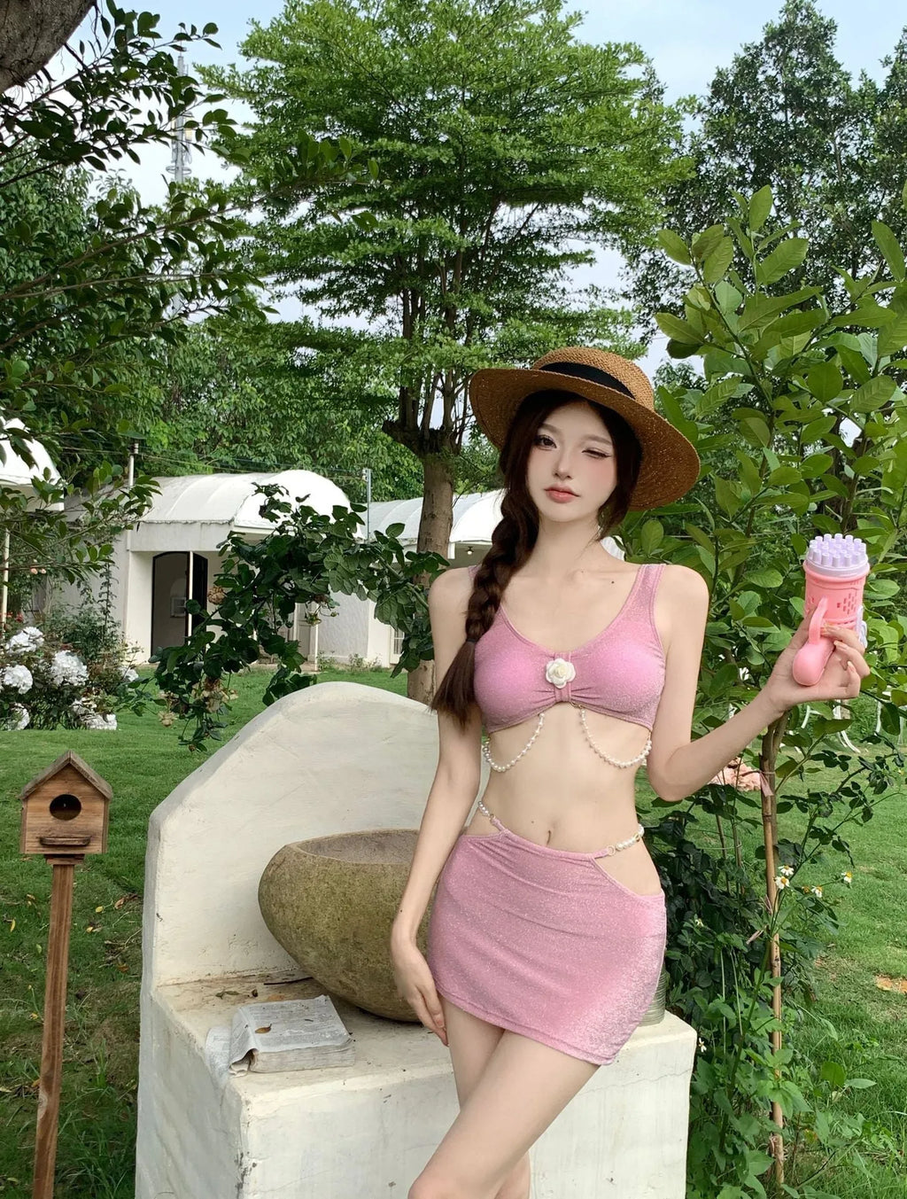 Pink and black women's three-piece bikini swimsuit on a white background.