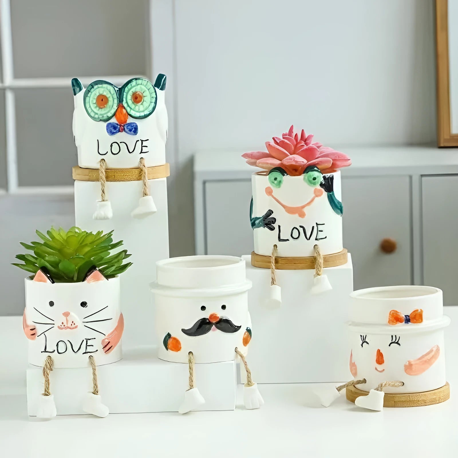 Cartoon style ceramic hanging foot succulent planter on a desktop.