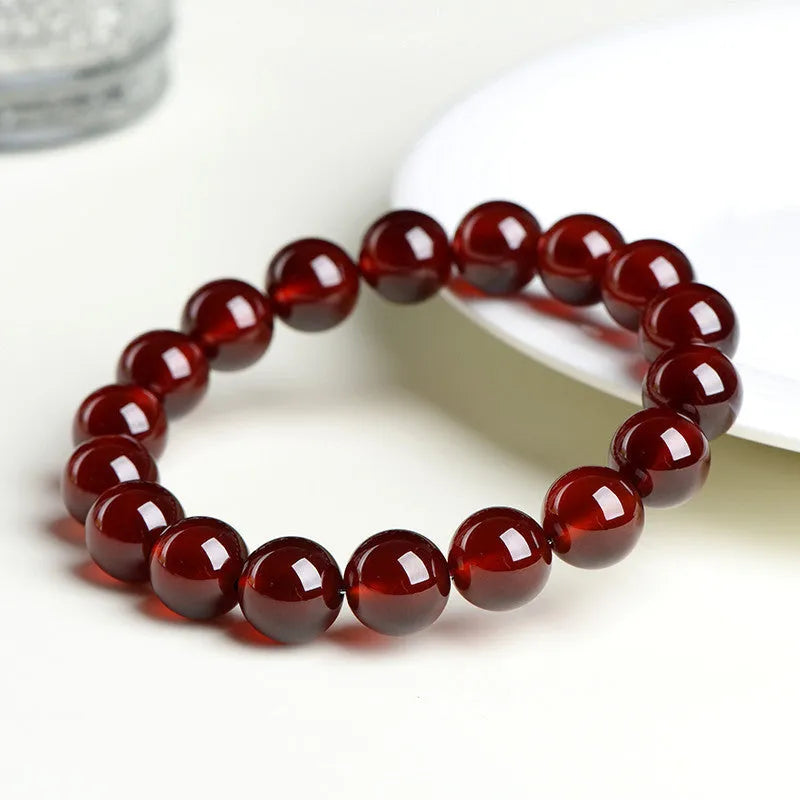 Natural orange red garnet ball bracelet with ruyi element in retro unisex design on wrist