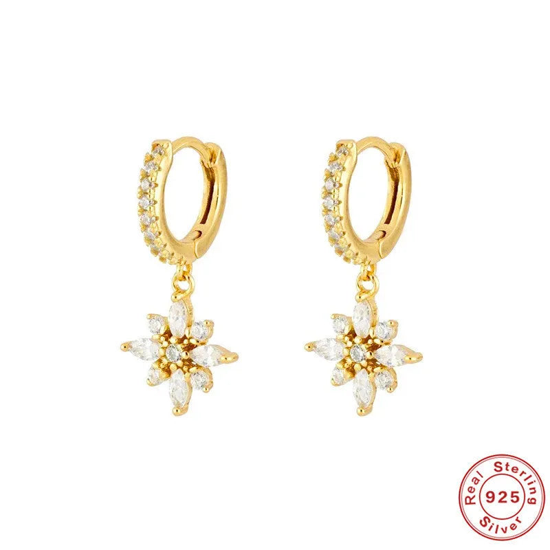 Pair of Sterling Silver snowflake pendant earrings on a yellow or white gold colour background.