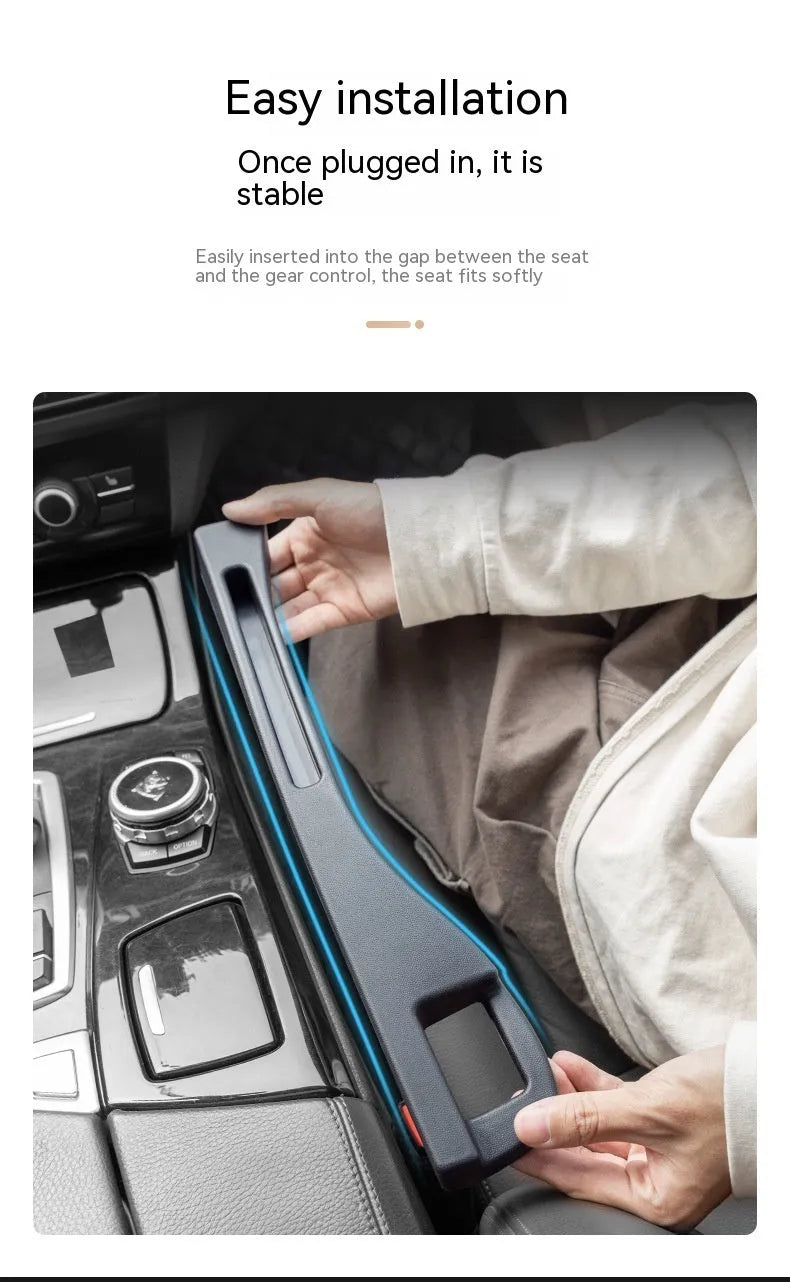 Black plastic car seat gap storage box with handle inserted between vehicle front seats.