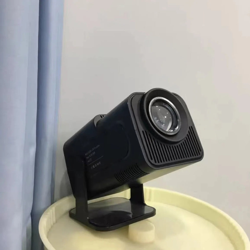 A white home projector unit on a wooden surface, showcasing its lens and wireless capabilities for HD projection.