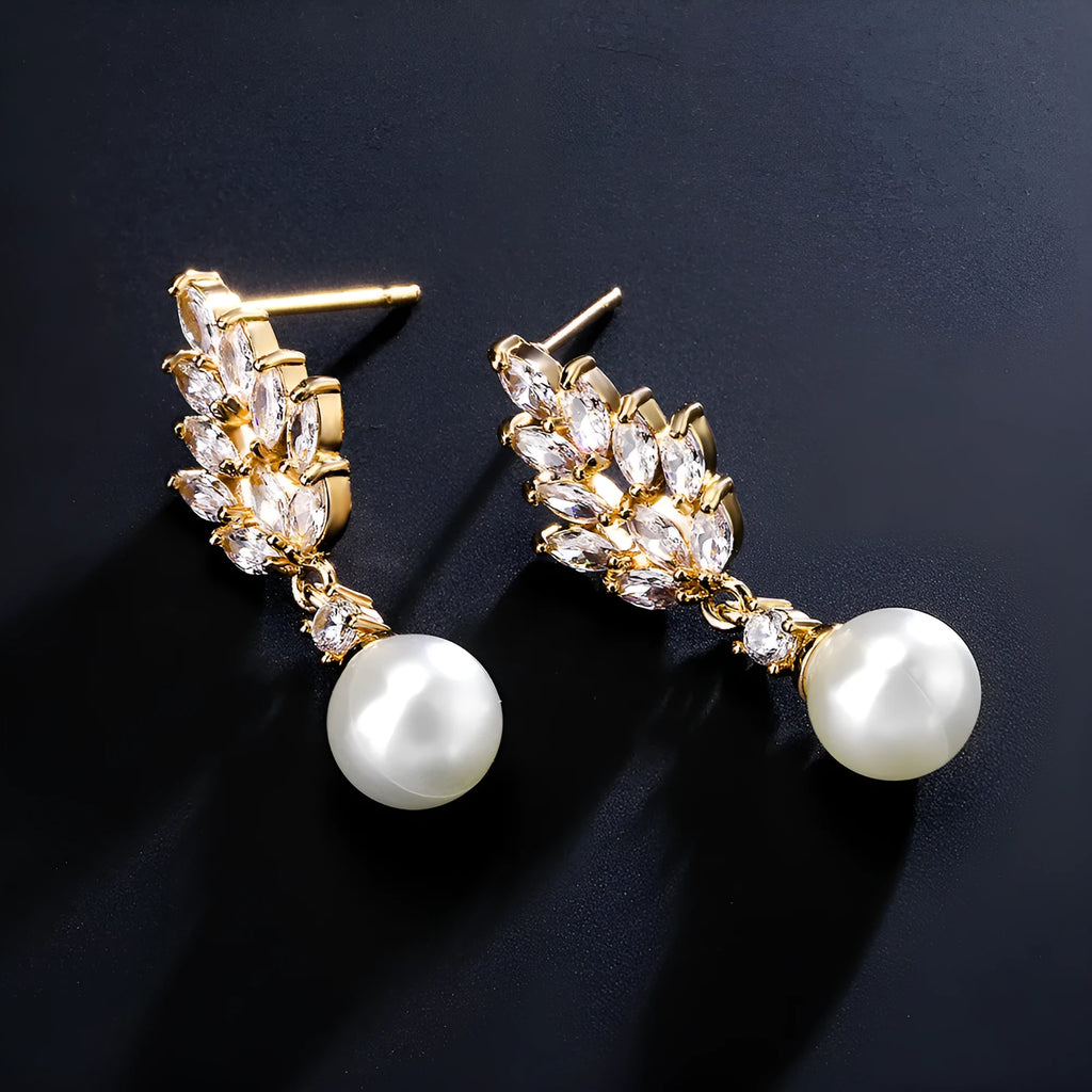 Geometric flower shaped earrings with micro inlaid zircon stones and pearl details on gold plating.