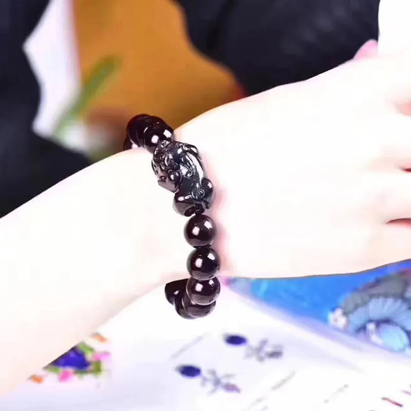 Natural ice colour eye obsidian crystal bead bracelet on a wrist, showing unisex design.