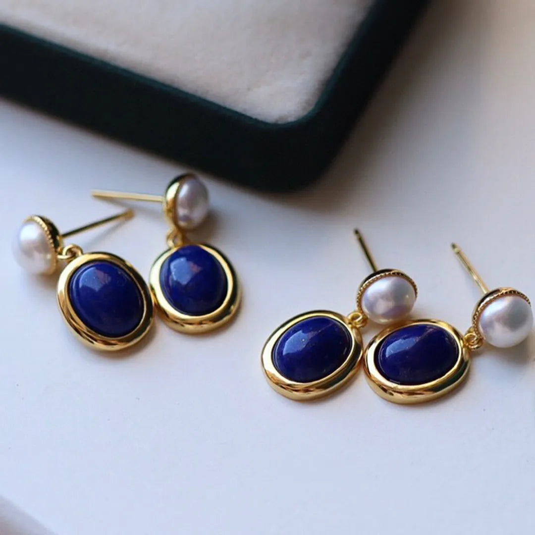 A pair of simple 925 silver earrings with a blue lapis lazuli pearl and auspicious pattern details.