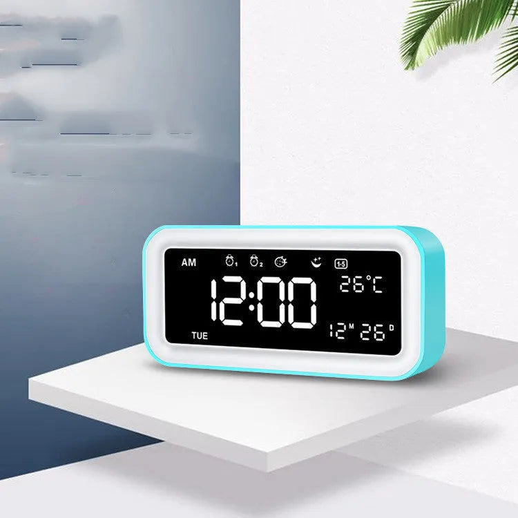 Blue rectangular LED digital alarm clock with atmosphere light on a bedside table.