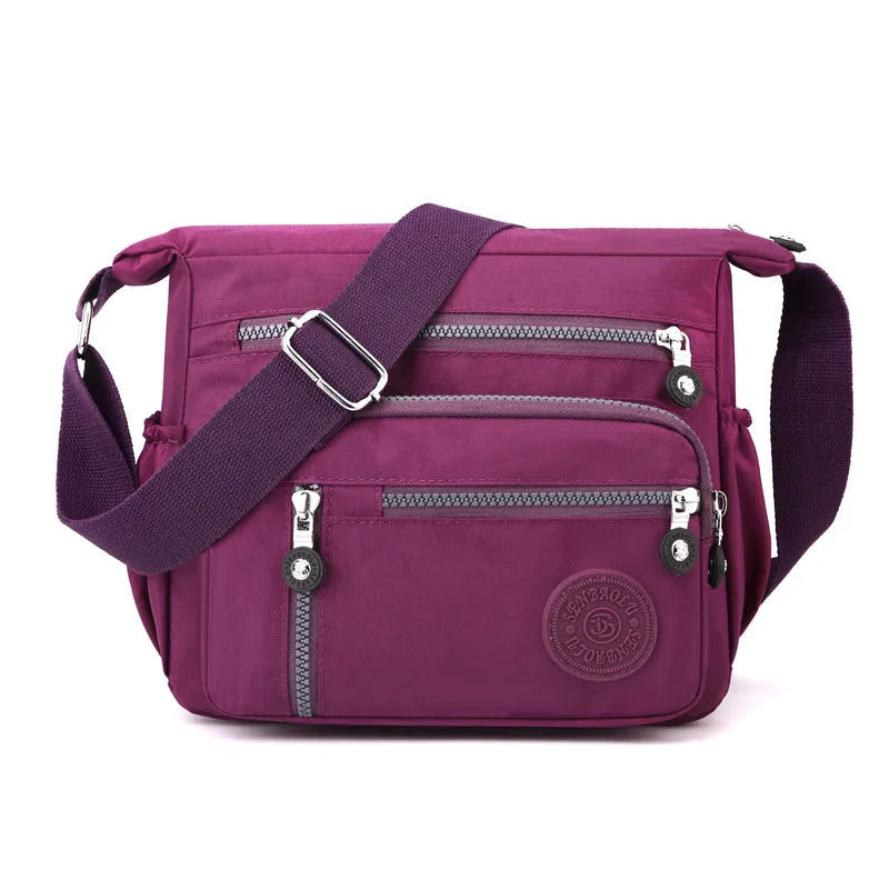 Grey nylon shoulder messenger bag with a single strap and square vertical shape on a neutral background.