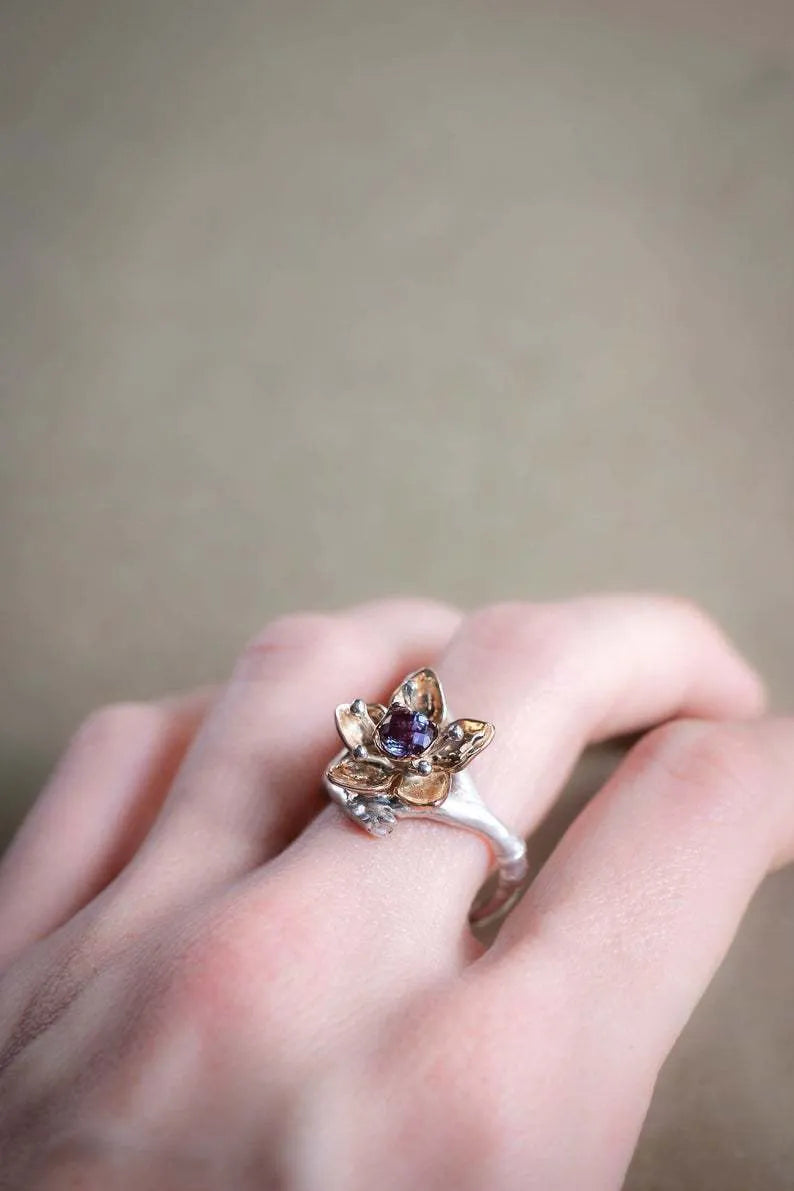 Silver two-tone women's ring with a geometric shape and floral design on a grey background