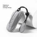 Suede car key cover in cement gray with style A design on a tabletop