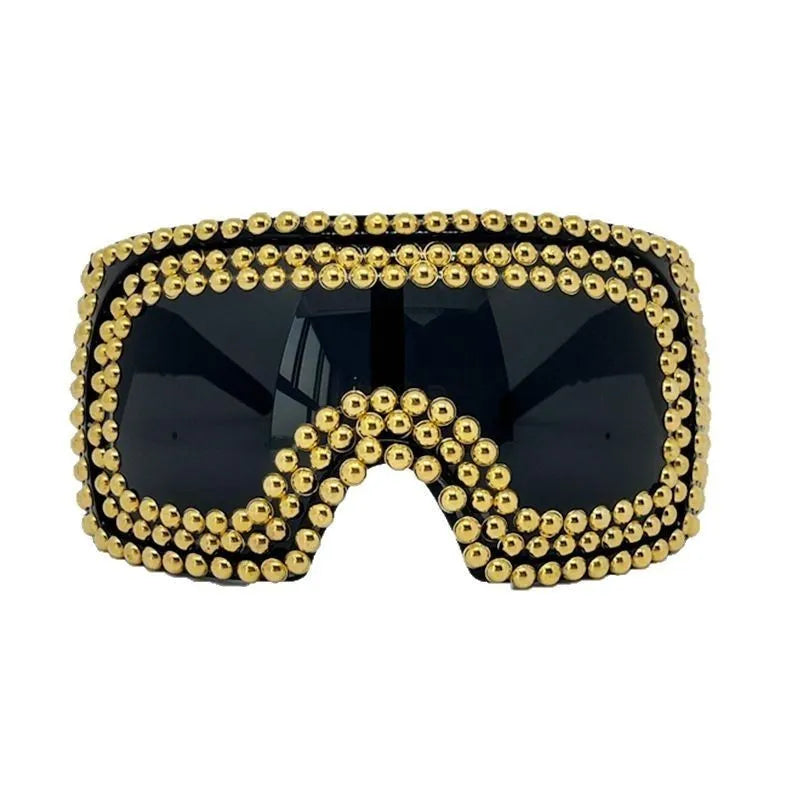 Punk sunglasses with large square frames and metal rivet details in gold colour