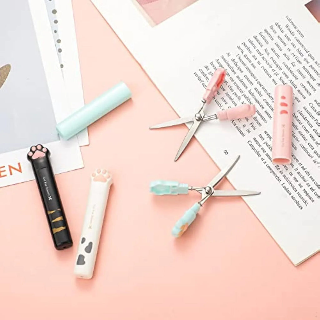 Small folding scissors with cat paw design on handles in choice of four colours, shown with blades safely closed.